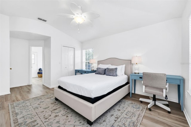 bedroom with light wood-type flooring, a closet, vaulted ceiling, and ceiling fan