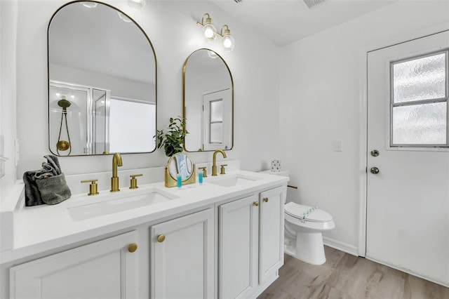 bathroom featuring wood-type flooring, vanity, toilet, and an enclosed shower