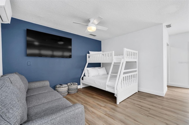 bedroom featuring hardwood / wood-style floors, a textured ceiling, and ceiling fan