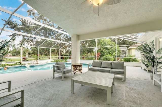 view of patio / terrace featuring glass enclosure, ceiling fan, and an outdoor hangout area