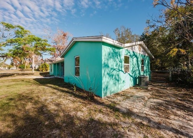 view of home's exterior with a lawn and central air condition unit