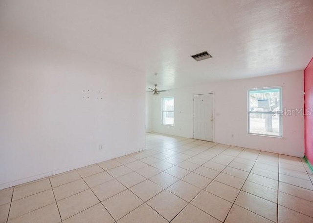 tiled spare room with ceiling fan