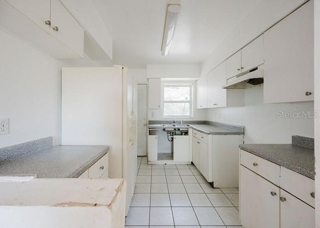 kitchen featuring white cabinetry, sink, and light tile patterned floors