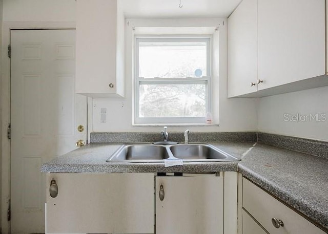 kitchen featuring sink and white cabinets