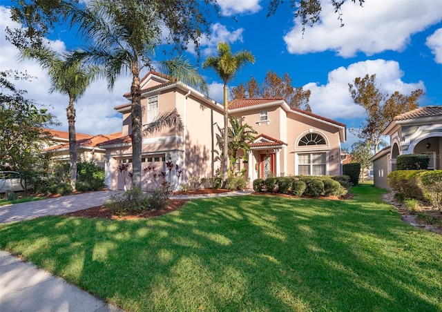 mediterranean / spanish home featuring a garage and a front lawn