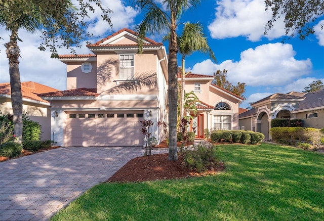 mediterranean / spanish-style home featuring a front lawn and a garage