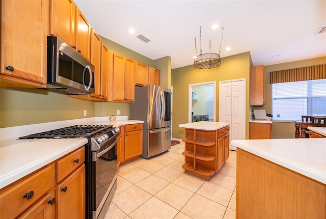 kitchen featuring a kitchen island, light tile patterned floors, and appliances with stainless steel finishes