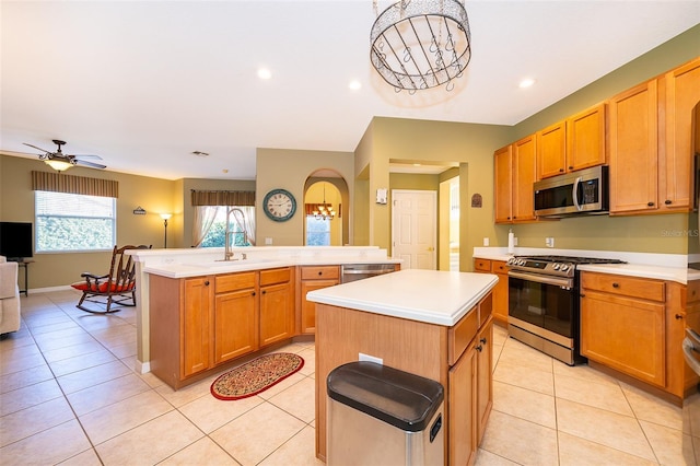 kitchen featuring a kitchen island with sink, ceiling fan, stainless steel appliances, and light tile patterned floors