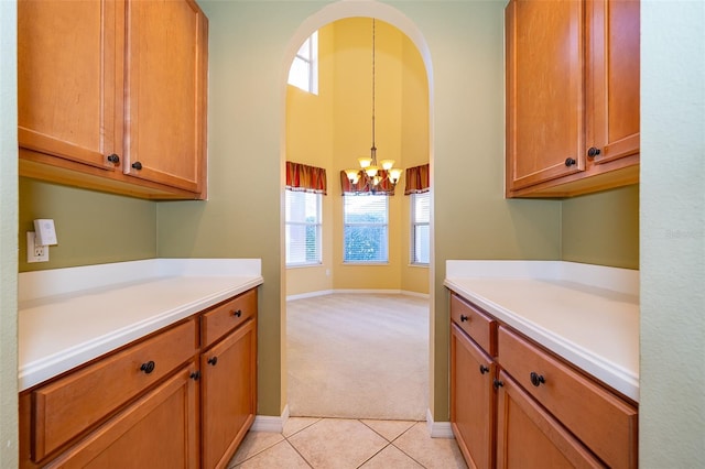 kitchen featuring light colored carpet, hanging light fixtures, and a notable chandelier