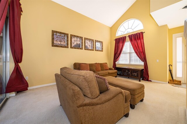 carpeted living room with high vaulted ceiling