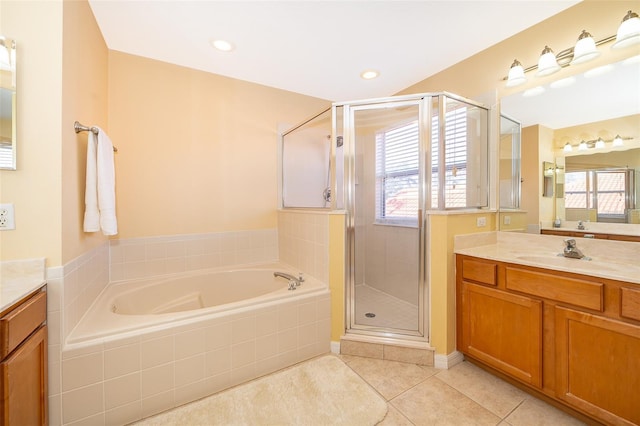 bathroom with independent shower and bath, tile patterned flooring, vanity, and a healthy amount of sunlight