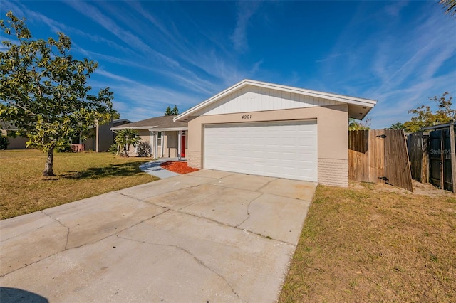 single story home with a garage and a front lawn