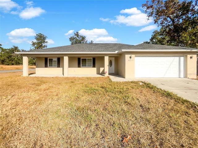 ranch-style house with covered porch, a garage, and a front yard