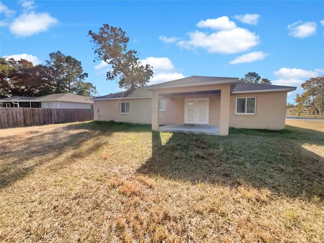 back of property featuring a lawn, a patio area, and french doors