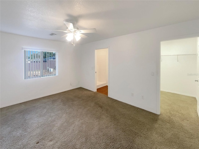 carpeted spare room with ceiling fan and a textured ceiling