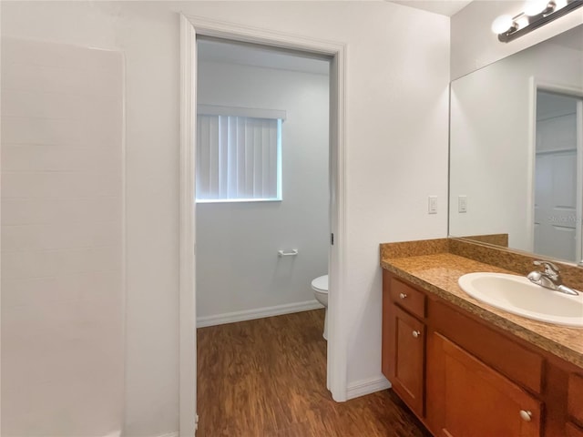 bathroom with hardwood / wood-style floors, vanity, and toilet