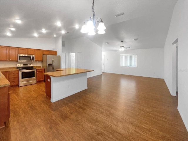 kitchen with hanging light fixtures, a center island, stainless steel appliances, and lofted ceiling