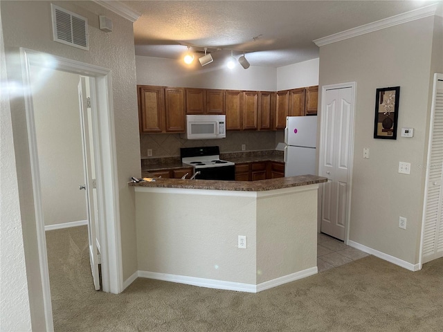 kitchen featuring light carpet, kitchen peninsula, a textured ceiling, white appliances, and crown molding