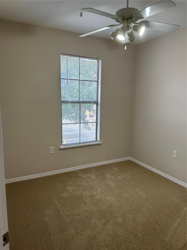 carpeted spare room featuring ceiling fan