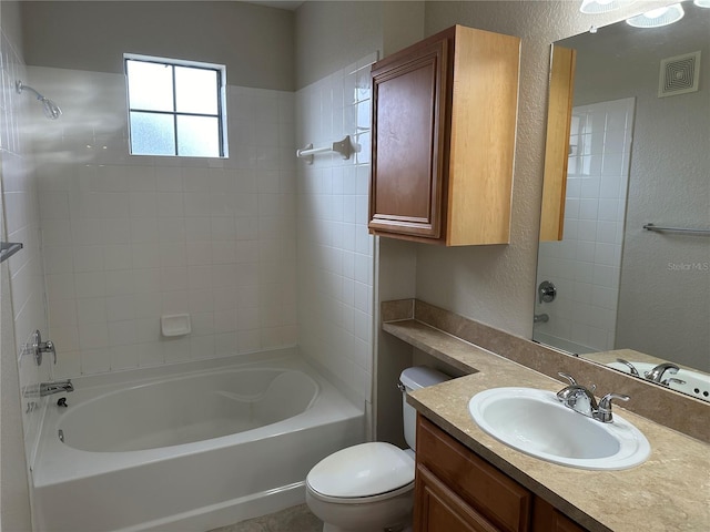 full bathroom with vanity, tiled shower / bath combo, and toilet