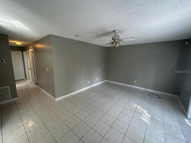 spare room with light tile patterned floors, a textured ceiling, and ceiling fan