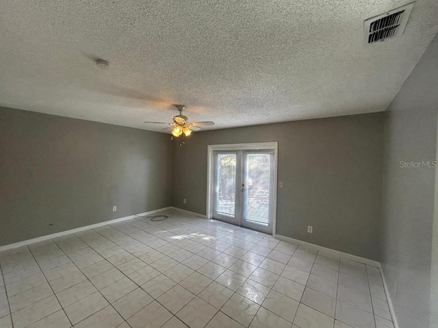 tiled spare room featuring french doors, ceiling fan, and a textured ceiling