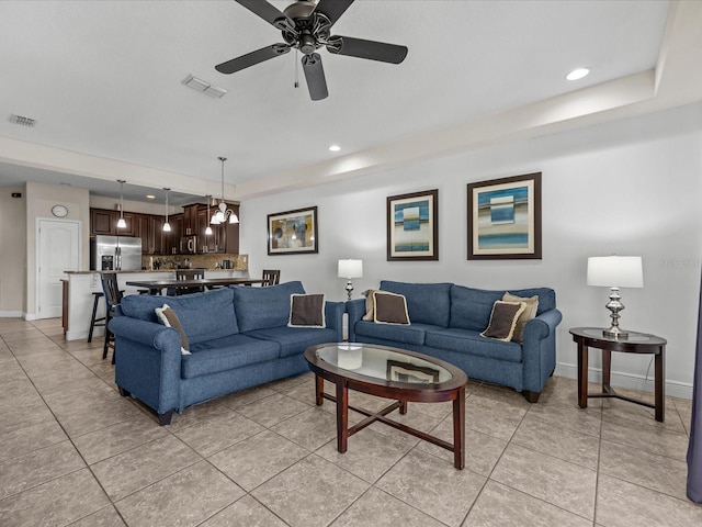 living room featuring light tile patterned floors and ceiling fan with notable chandelier