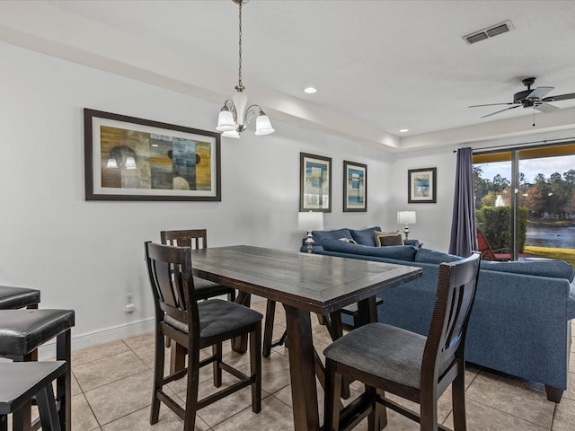 dining room with light tile patterned floors and ceiling fan with notable chandelier