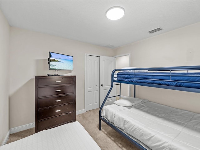 bedroom featuring a closet and light colored carpet