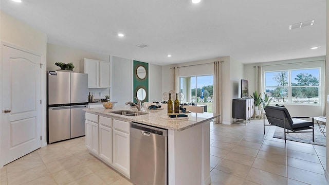 kitchen with white cabinets, a center island with sink, sink, appliances with stainless steel finishes, and plenty of natural light