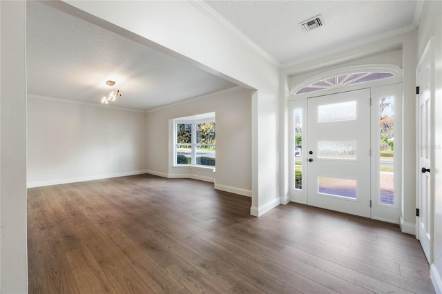 foyer entrance with a textured ceiling, crown molding, dark wood-type flooring, and an inviting chandelier