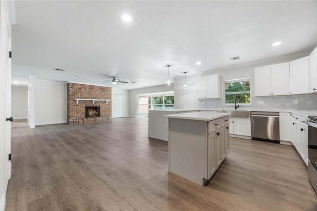 kitchen featuring white cabinetry, a center island, wood-type flooring, and appliances with stainless steel finishes