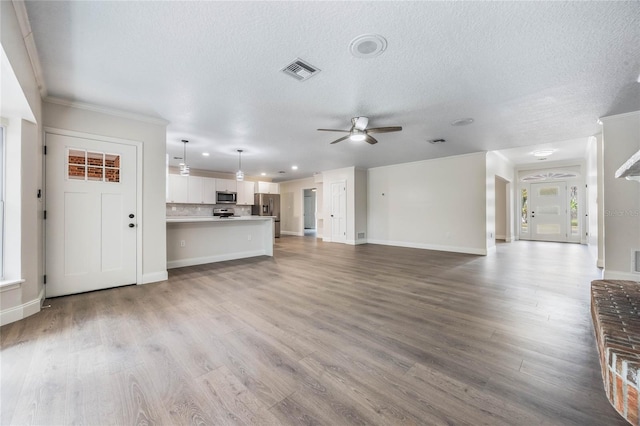 unfurnished living room with a textured ceiling, light hardwood / wood-style flooring, ceiling fan, and ornamental molding