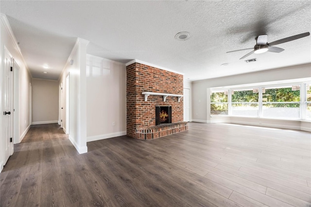 unfurnished living room with dark hardwood / wood-style floors, ceiling fan, ornamental molding, and a fireplace