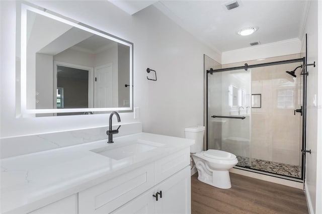 bathroom featuring crown molding, vanity, wood-type flooring, and toilet