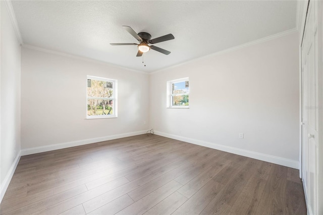 spare room featuring dark hardwood / wood-style floors, ceiling fan, ornamental molding, and a textured ceiling