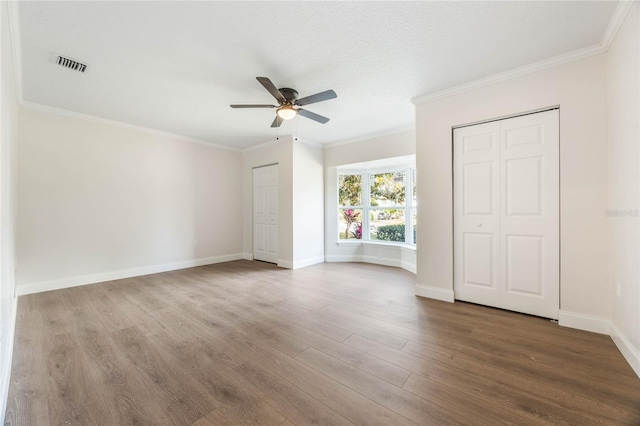 spare room with wood-type flooring, a textured ceiling, ceiling fan, and ornamental molding