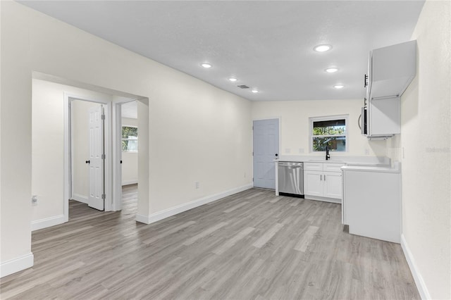 interior space with a textured ceiling, light wood-type flooring, lofted ceiling, and sink