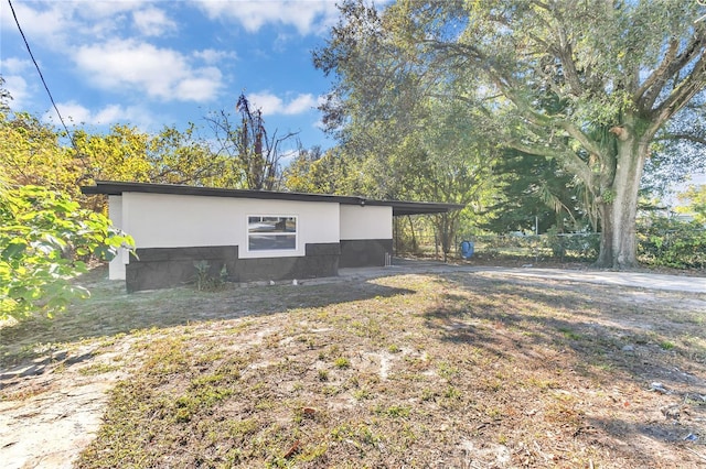 view of home's exterior featuring a lawn and a carport