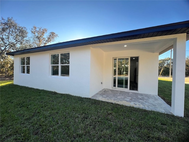 rear view of property featuring a patio area and a yard