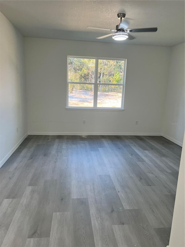 spare room with ceiling fan and light wood-type flooring