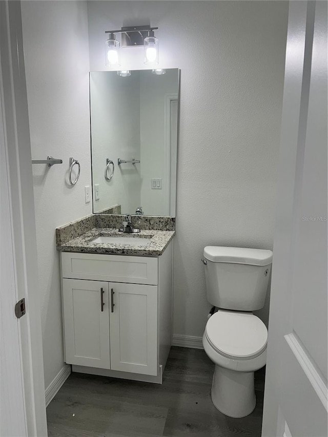 bathroom featuring hardwood / wood-style floors, vanity, and toilet