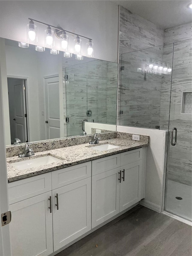 bathroom featuring wood-type flooring, vanity, and an enclosed shower