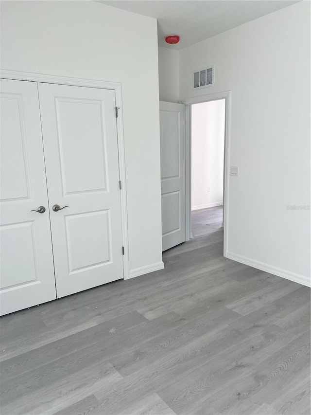 unfurnished bedroom featuring light hardwood / wood-style floors and a closet