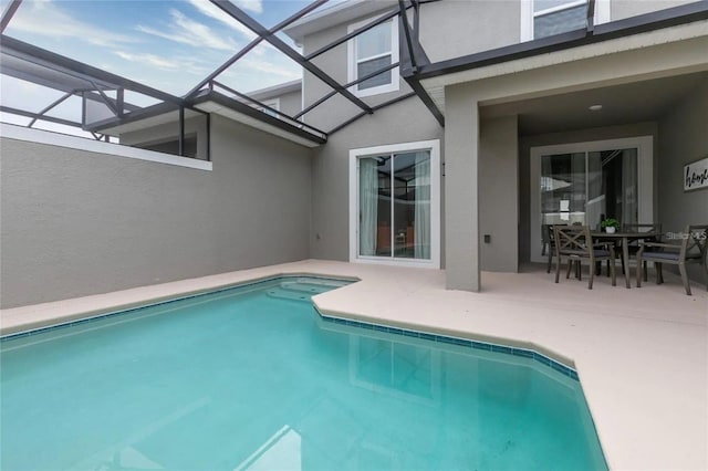 view of swimming pool featuring glass enclosure and a patio area