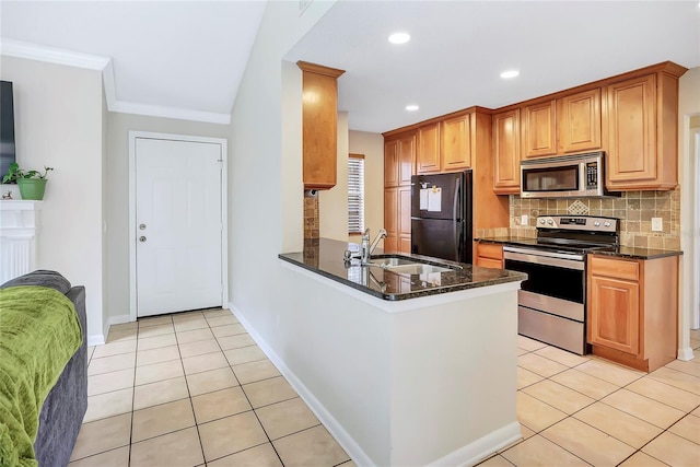 kitchen with sink, kitchen peninsula, dark stone countertops, light tile patterned floors, and appliances with stainless steel finishes