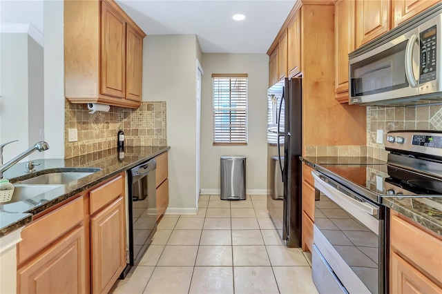 kitchen featuring sink, backsplash, dark stone countertops, light tile patterned flooring, and black appliances