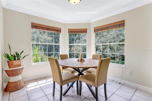 tiled dining space with a textured ceiling and crown molding