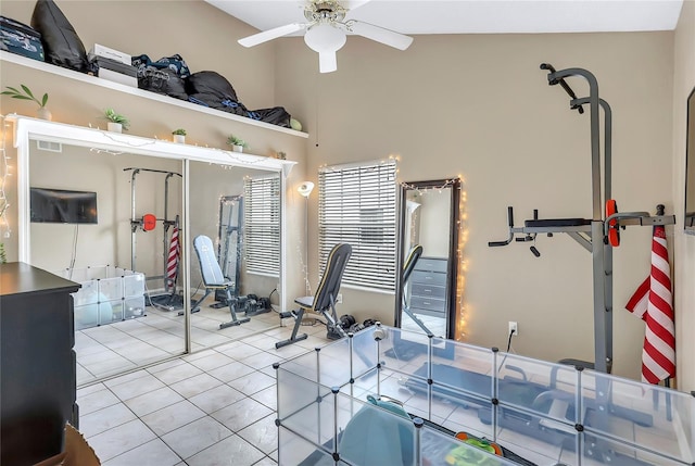 interior space featuring ceiling fan, light tile patterned flooring, and vaulted ceiling