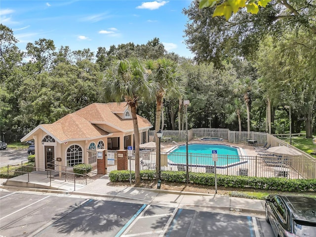 view of swimming pool featuring a patio and a hot tub